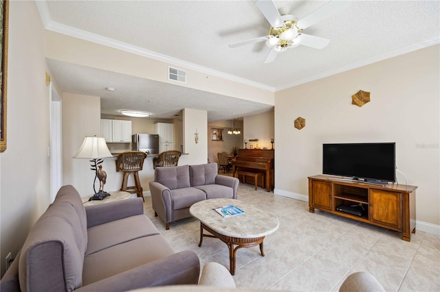 living area featuring a textured ceiling, ceiling fan, visible vents, baseboards, and ornamental molding