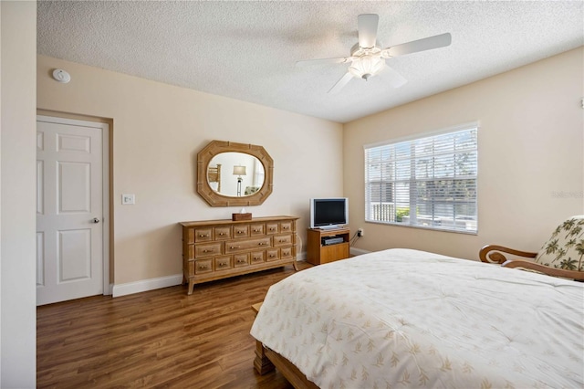 bedroom featuring a textured ceiling, wood finished floors, and baseboards