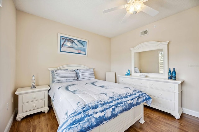 bedroom featuring visible vents, dark wood-type flooring, ceiling fan, a textured ceiling, and baseboards