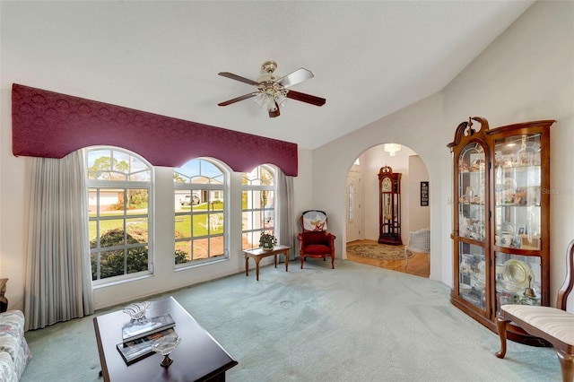 living area with light carpet, vaulted ceiling, and ceiling fan