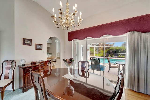 dining room featuring a chandelier, vaulted ceiling, and light hardwood / wood-style floors