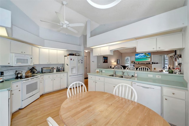 kitchen featuring lofted ceiling, white cabinetry, kitchen peninsula, and white appliances