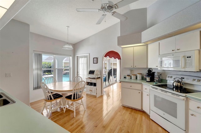 kitchen featuring hanging light fixtures, light wood-type flooring, white cabinetry, white appliances, and ceiling fan