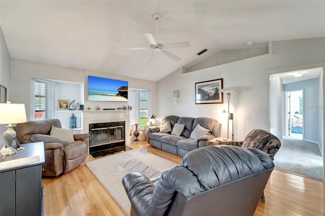 living room with light hardwood / wood-style floors, lofted ceiling, and ceiling fan