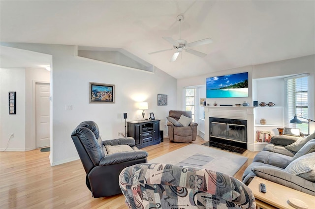 living room with light hardwood / wood-style flooring, ceiling fan, and vaulted ceiling