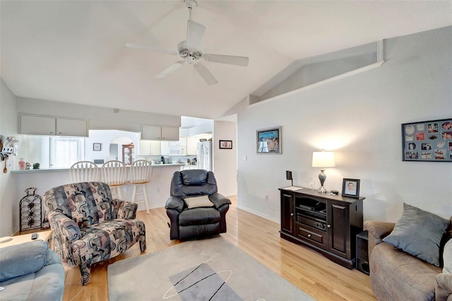 living room featuring lofted ceiling, light hardwood / wood-style flooring, and ceiling fan