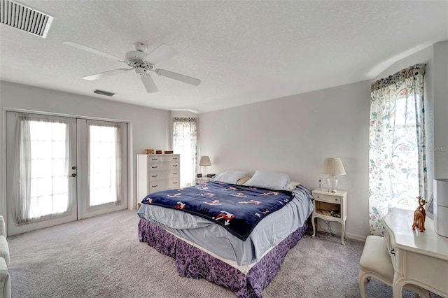 carpeted bedroom with french doors, ceiling fan, a textured ceiling, and access to exterior