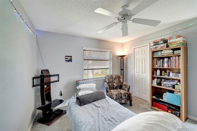 bedroom featuring a closet, ceiling fan, light carpet, and a textured ceiling