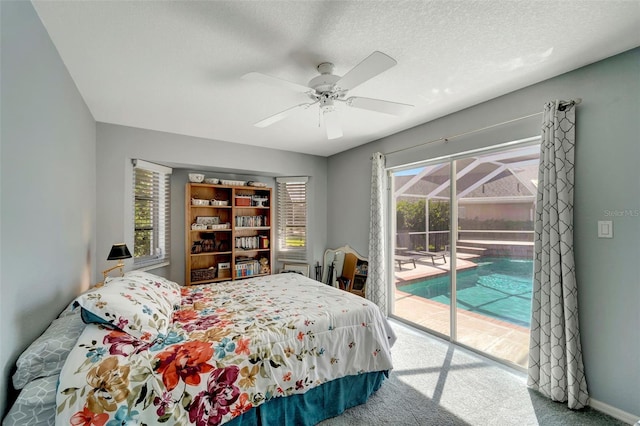 carpeted bedroom featuring a textured ceiling, multiple windows, access to outside, and ceiling fan