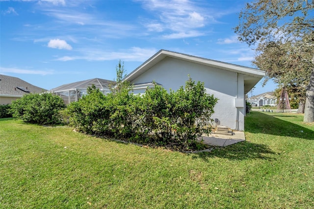 view of property exterior with a lanai and a lawn