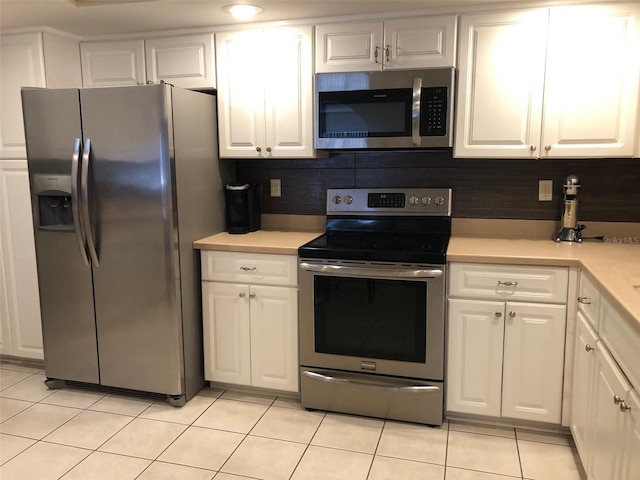 kitchen featuring white cabinets, light tile patterned floors, stainless steel appliances, and tasteful backsplash