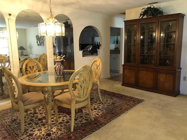 dining space with light colored carpet and an inviting chandelier