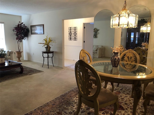 carpeted dining area featuring an inviting chandelier