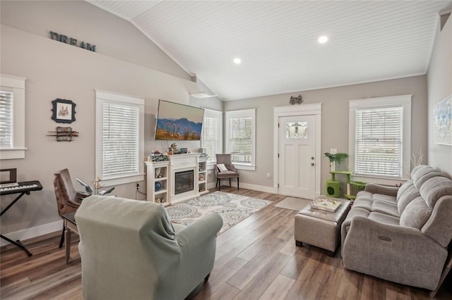 living room featuring hardwood / wood-style flooring, a wealth of natural light, and vaulted ceiling