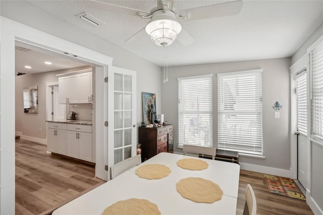 dining space featuring hardwood / wood-style floors, a textured ceiling, and ceiling fan