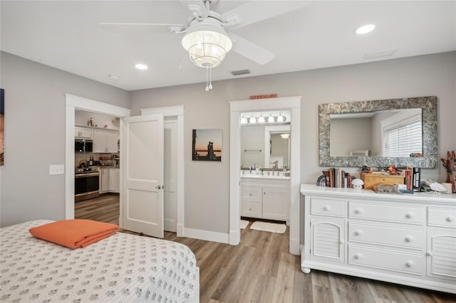 bedroom with ceiling fan, light hardwood / wood-style floors, and ensuite bathroom