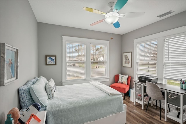 bedroom with dark hardwood / wood-style flooring, multiple windows, and ceiling fan