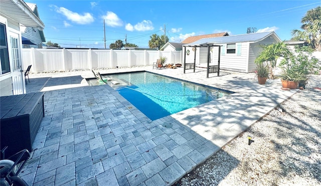 view of swimming pool featuring an outbuilding and a patio area