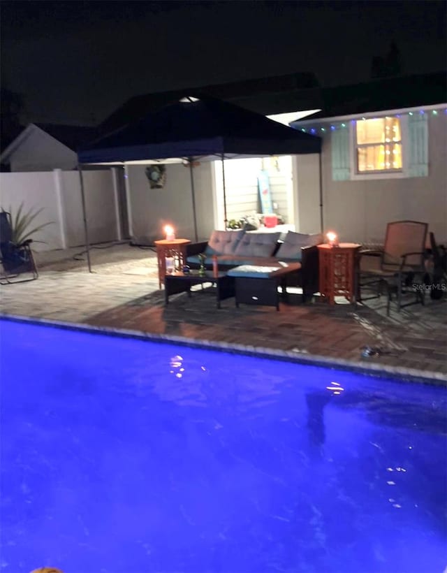 pool at night with a patio area