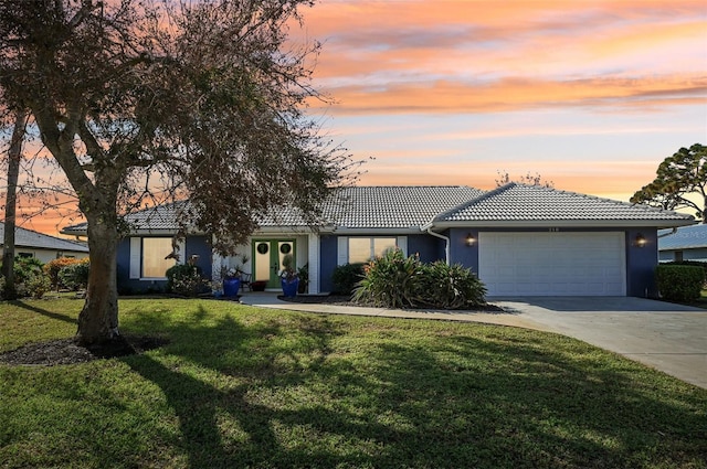 218 Brandywine Cir, Englewood, FL 34223 - view of front of property with a garage, stucco siding, concrete driveway, a tiled roof, and a yard