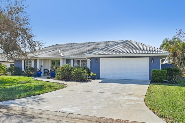 ranch-style home featuring a front lawn and a garage