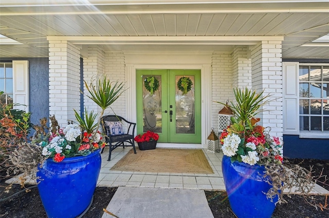 218 Brandywine Cir, Englewood, FL 34223 - view of exterior entry with covered porch, brick siding, and french doors