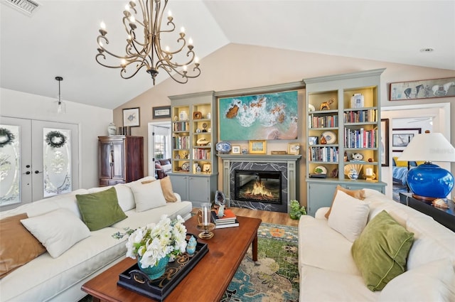 218 Brandywine Cir, Englewood, FL 34223 - living room with an inviting chandelier, visible vents, wood finished floors, a high end fireplace, and vaulted ceiling