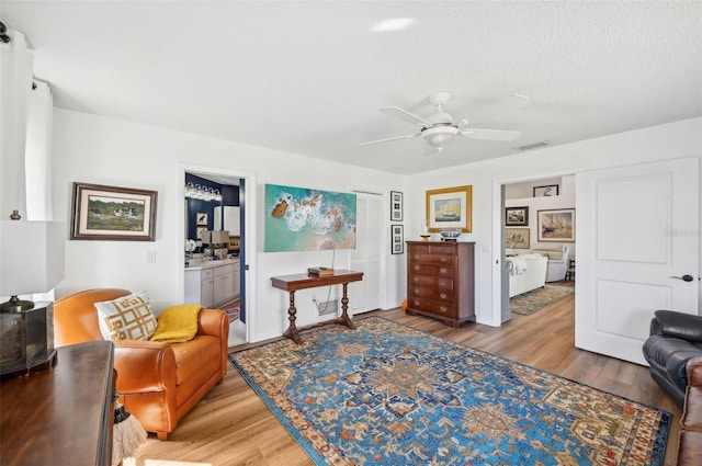 218 Brandywine Cir, Englewood, FL 34223 - sitting room featuring a textured ceiling, ceiling fan, wood finished floors, and visible vents