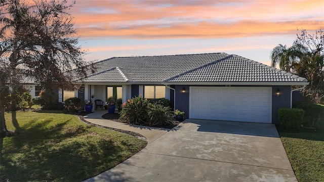 218 Brandywine Cir, Englewood, FL 34223 - single story home featuring a front lawn, stucco siding, a tiled roof, concrete driveway, and an attached garage