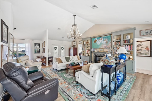 218 Brandywine Cir, Englewood, FL 34223 - living room featuring lofted ceiling, a chandelier, light wood finished floors, and a premium fireplace