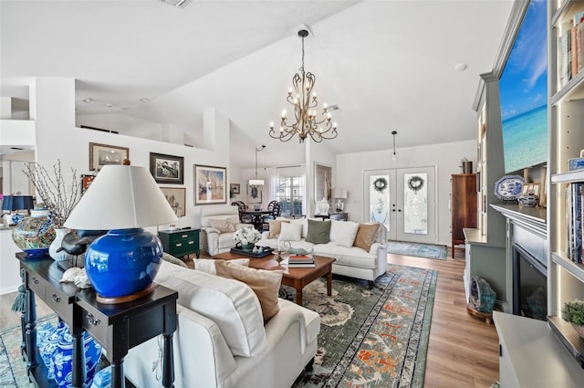 218 Brandywine Cir, Englewood, FL 34223 - living area featuring light wood-type flooring, a chandelier, and vaulted ceiling