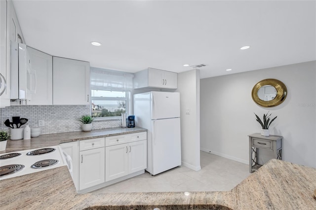 kitchen featuring light stone counters, light tile patterned flooring, backsplash, white cabinets, and white appliances