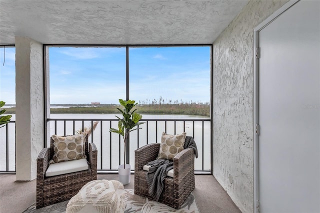 sunroom featuring a wealth of natural light and a water view