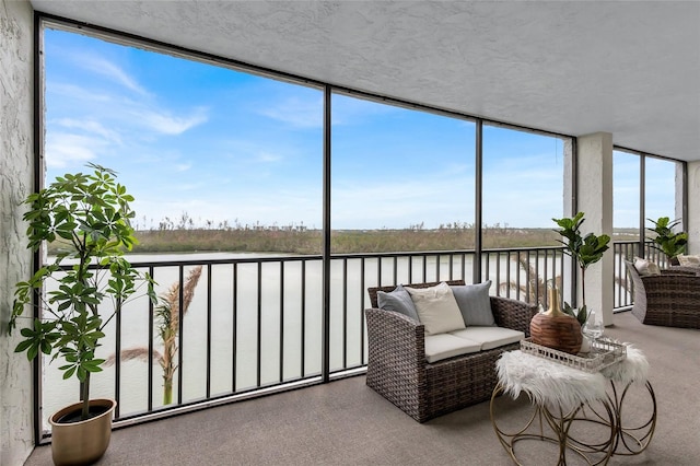 sunroom featuring a water view