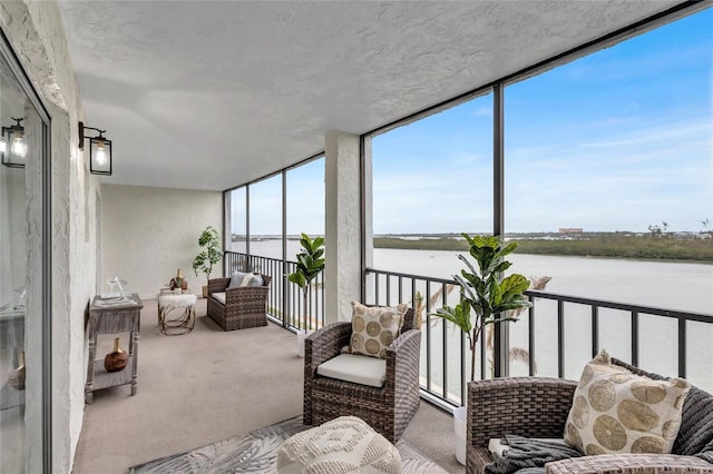 sunroom featuring a water view