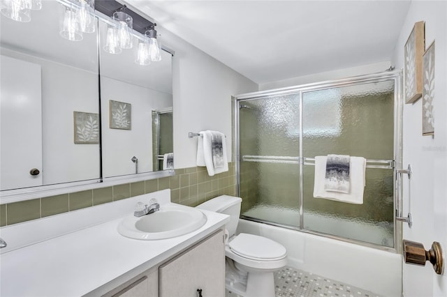 full bathroom featuring tile patterned floors, backsplash, vanity, toilet, and combined bath / shower with glass door