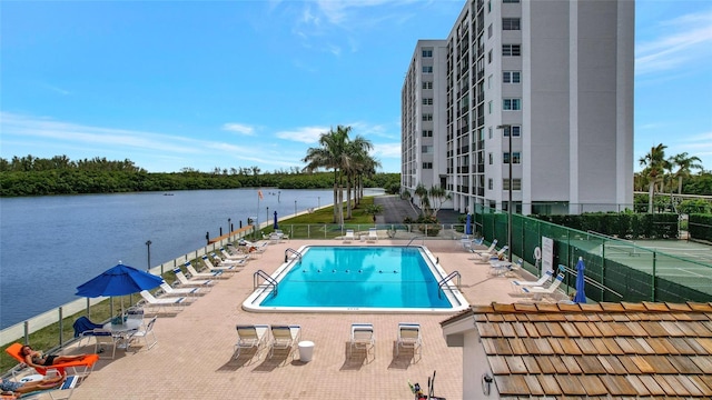 view of pool featuring a patio and a water view