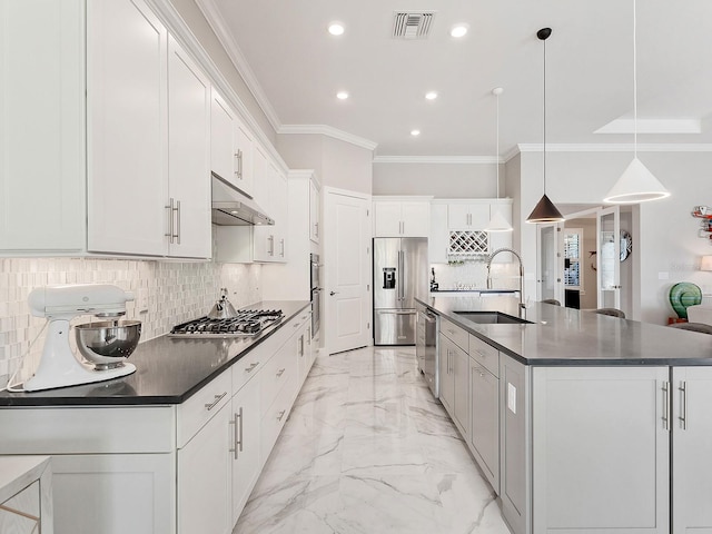 kitchen featuring sink, hanging light fixtures, stainless steel appliances, an island with sink, and white cabinets