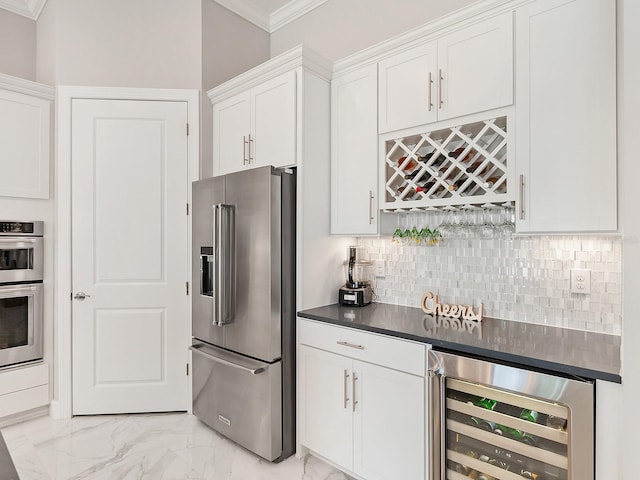 kitchen with crown molding, decorative backsplash, appliances with stainless steel finishes, white cabinetry, and beverage cooler