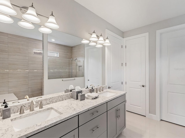 bathroom with a tile shower, vanity, and a notable chandelier