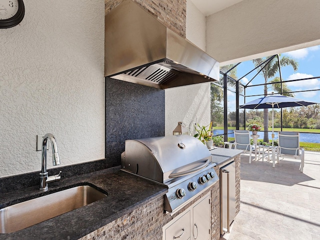 view of patio / terrace with an outdoor kitchen, area for grilling, sink, and glass enclosure