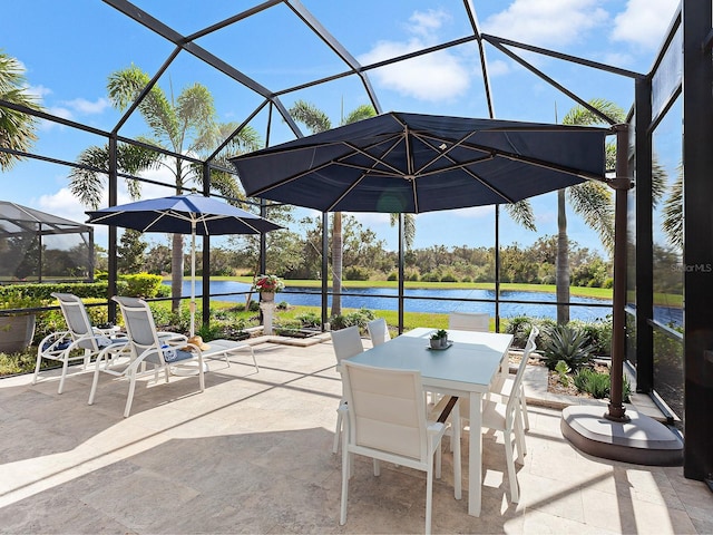 view of patio featuring a lanai and a water view