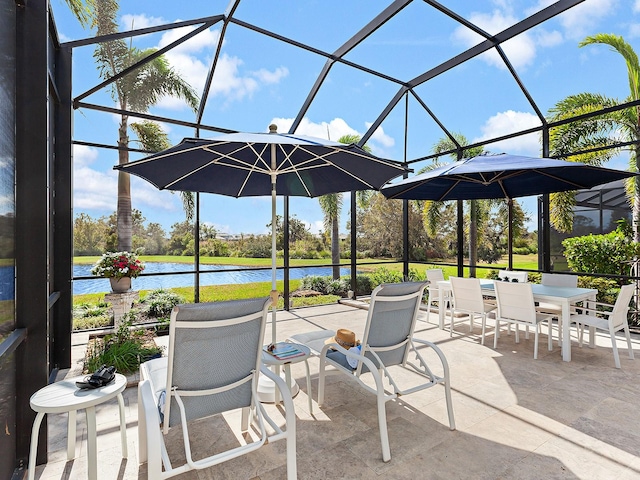 view of patio / terrace with a lanai and a water view