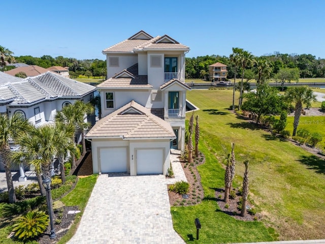 view of front facade with a front yard, a balcony, and a garage