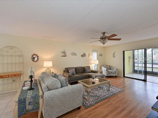 living room featuring a textured ceiling, light hardwood / wood-style floors, and ceiling fan