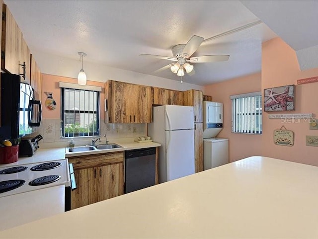 kitchen featuring hanging light fixtures, backsplash, stacked washer and dryer, sink, and white appliances