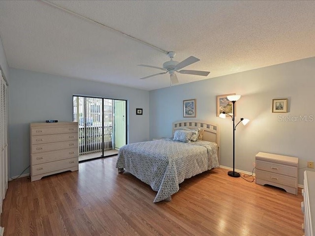 bedroom featuring ceiling fan, hardwood / wood-style flooring, a textured ceiling, and access to exterior