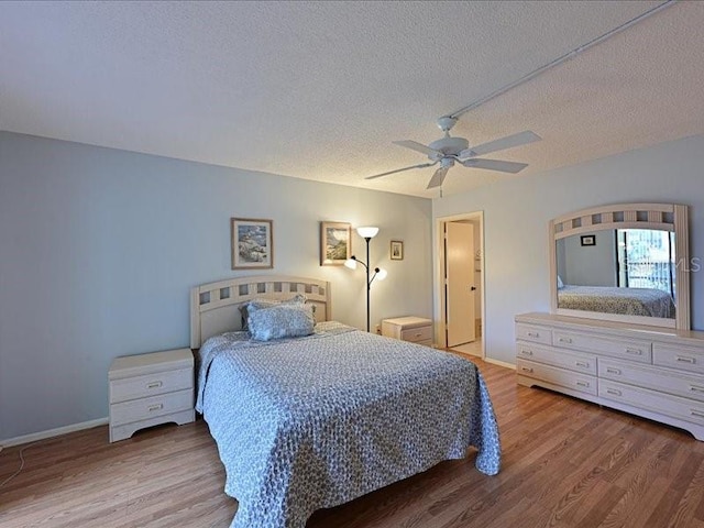 bedroom featuring ceiling fan, a textured ceiling, and light hardwood / wood-style flooring