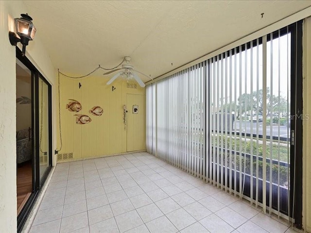 unfurnished sunroom featuring ceiling fan