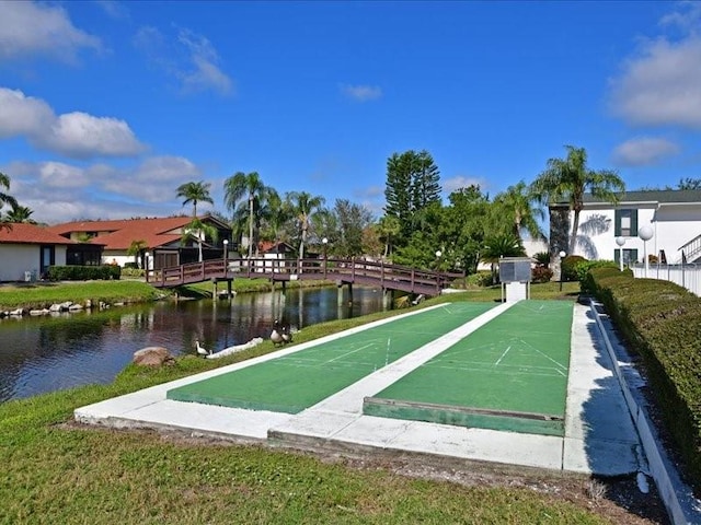 surrounding community with a lawn and a water view